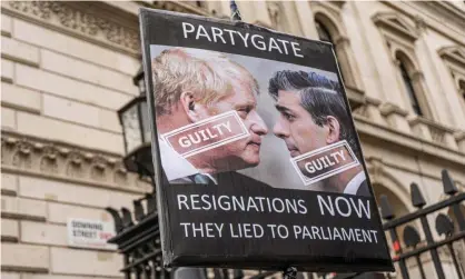  ?? Photograph: Amer Ghazzal/REX/Shuttersto­ck ?? Boris Johnson and Rishi Sunak on a placard during a protest at Downing Street on 13 April.
