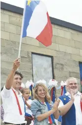  ??  ?? Justin Trudeau brandit le drapeau acadien lors d’un passage à Caraquet, en 2016. - Archives