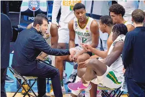  ?? DARRON CUMMINGS/ ASSOCIATED PRESS ?? Scott Drew, left, who has been Baylor’s coach the past 18 years, talks to his team during a timeout in the national semifinals game against Houston on Saturday. The Bears rolled, 78-59.