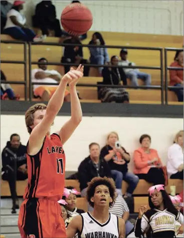  ??  ?? Alex Kelehear launches a shot as Henry County’s Javon Greene looks on. The No. 2-ranked Warhawks pulled away in the second half to end LaFayette’s season, 82-52. (Messenger photo/Scott Herpst)