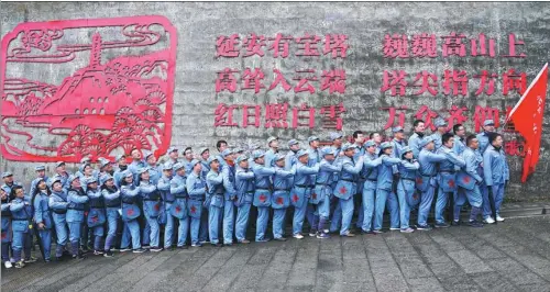  ?? HUO YAN / CHINA DAILY ?? Wearing uniforms of the Eighth Route Army, tourists capture the moment at Baota Mountain, which is named after Baota Tower, in Yan’an, Shaanxi province, earlier this month.