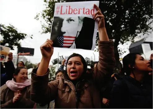  ?? DOLOreS OchOA / The ASSOcIATed PreSS ?? A woman holds up the Spanish hashtag #Freedom on Thursday at a protest against the arrest of WikiLeaks founder Julian Assange outside the Foreign Ministry in Quito, Ecuador.