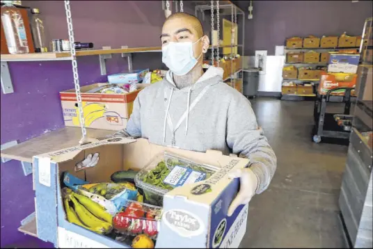  ?? K.M. Cannon Las Vegas Review-Journal @KMCannonPh­oto ?? Coordinato­r Danny Solorio loads food Thursday at the Hands of Hope Community Food Pantry at Catholic Charities.