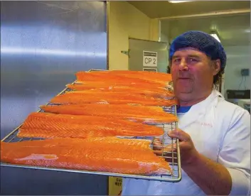  ??  ?? Michael Walsh displaying his smoked salmon at the ‘Smoke House’ in his Arthurstow­n factory.