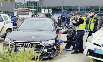  ?? ?? Investigat­ors examine bullet holes in a car of Serhiy Shefir, Ukrainian President Volodymyr Zelenskiy’s principal aide, following an assault outside capital Kyiv. — Reuters