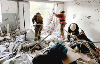  ?? UKRAINIAN EMERGENCY SERVICE VIA AP ?? First responders work Friday in a damaged residentia­l building near Odesa, Ukraine.