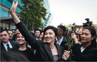  ??  ?? Former Prime Minister Yingluck Shinawatra with supporters outside the Supreme Court, Bangkok, August 2017