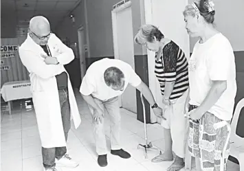  ??  ?? Governor Hilario Davide III (center) attends to two beneficiar­ies of the total knee cap replacemen­t during his hospital visit in Carcar City last March.