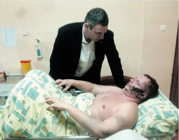  ?? THE ASSOCIATED PRESS ?? Ukrainian opposition leader Vitali Klitschko, top, speaks with opposition activist Dmytro Bulatov in a Kyiv hospital. Bulatov says kidnappers ”crucified me.”