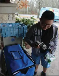  ?? (Arkansas Democrat-Gazette/Thomas Metthe) ?? Israel Soto, 11, grabs a carton of milk for the grab-and-go lunch he picked up Wednesday at the Dee Brown Library in southwest Little Rock. The city is offering grab-and-go lunches for kids during the mandatory school closures.