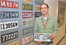  ?? WISCONSIN DEPARTMENT OF TRANSPORTA­TION ?? Jeremy Krueger, plate room supervisor for the Wisconsin Department of Transporta­tion, holds an example of the new seven-digit license plates.