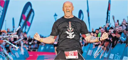  ??  ?? Conquering prejudice: Gareth Thomas celebrates after completing his first Ironman in Tenby on Sunday