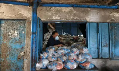  ??  ?? A Palestinia­n aid worker prepares food supplies at a UNRWA distributi­on centre in Gaza. Photograph: Mohammed Salem/Reuters