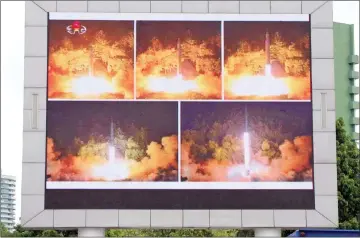  ??  ?? Coverage of an ICBM missile test is displayed on a screen in a public square in Pyongyang. — AFP photo