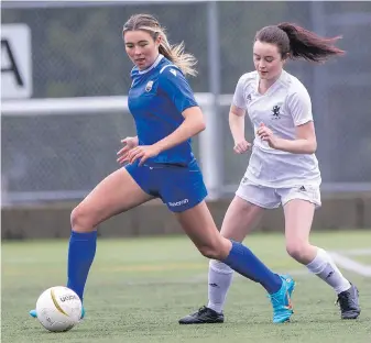  ?? DARREN STONE, TIMES COLONIST ?? St. Michaels University School Blue Jags Amanda Adams moves the ball past Glenlyon Norfolk School Griffins Olivia Dunkley in Ryan Cup quarter-final action at the UVic turf soccer fields on Thursday. SMUS went on to win 1-0.