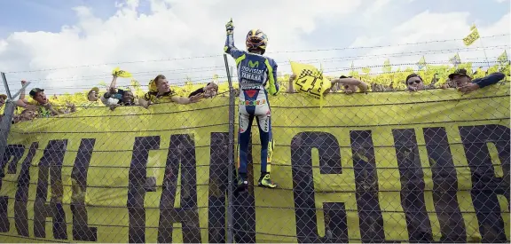  ?? (Getty Images) ?? Sotto la curva
Valentino Rossi, 36 anni, festeggia con
i sui tifosi la vittoria numero 111 in carriera, 3ª stagionale e il 12° podio di fila. Il decimo titolo mondiale dopo questa prestazion­e
sembra sempre più
possibile