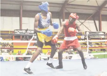  ??  ?? Barbados’ Tevin Brewster (left) mixing it up against Shemar Morrison Friday night at the National Gymnasium.