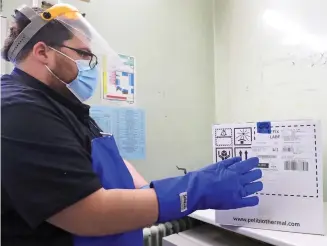  ??  ?? Grand opening: A technician at Croydon hospital unpacks the first vials
