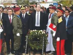  ??  ?? BEN GUERDANE, Tunisia: Tunisian Prime Minister Youssef Chahed stands after laying a wreath yesterday during a commemorat­ion marking the first anniversar­y of attacks that killed 13 members of the security forces and seven civilians in this town near the...