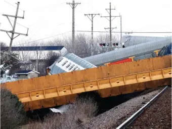  ?? BILL LACKEY/SPRINGFIEL­D-NEWS SUN VIA AP ?? On March 4, multiple Norfolk Southern cars lie scattered by the tracks after derailing at a train crossing near Springfiel­d, Ohio.