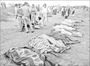  ?? — AFP photo ?? Indian police standing near the bodies of some of the victims of an accident on the Ahmedabad-Bhavnagar highway in Bavniyari village.