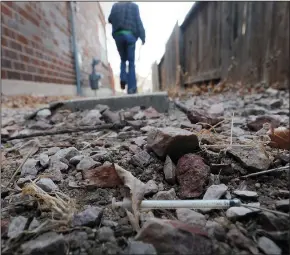  ?? CHRISTIAN MURDOCK/COLORADO SPRINGS GAZETTE ?? Lauren Hardy walks past a used syringe lying in the dirt next to their Colorado Springs home, March 24, 2011.