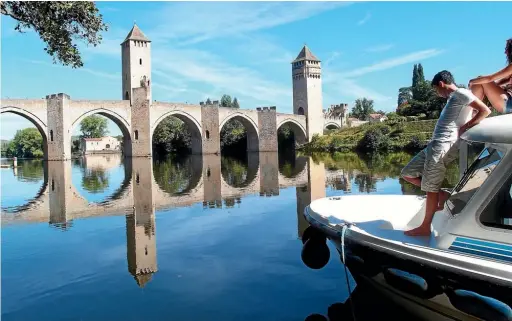  ??  ?? The beautiful Valentre bridge, a brilliant example of Gothic architectu­re, in Cahors.