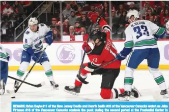  ??  ?? NEWARK: Brian Boyle #11 of the New Jersey Devils and Henrik Sedin #33 of the Vancouver Canucks watch as Jake Virtanen #18 of the Vancouver Canucks controls the puck during the second period at the Prudential Center in Newark. — AFP