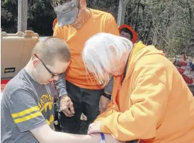  ?? LYNN CURWIN/TRURO NEWS ?? Caleb Isaac Gloade had a radio transmitte­r bracelet fitted by Project Lifesaver volunteers Doug Mcnutt and Darlene Colpitts.