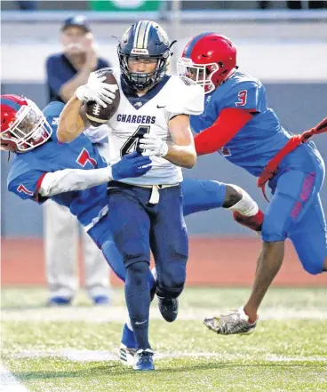  ?? [PHOTO BY NATE BILLINGS, THE OKLAHOMAN] ?? Heritage Hall’s Conner Carey breaks away from John Marshall’s Che’Don Caldwell, left, and Jalen Shells on a long catch during Friday’s game at Taft Stadium in Oklahoma City. Heritage Hall won, 27-20.