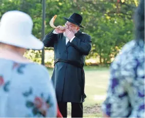  ??  ?? Rabbi Ovadia Goldman blows the shofar during “Shofar in the Park,” a Rosh Hashana service held Tuesday at Quail Creek Park in Oklahoma City.