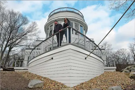  ?? DANA JENSEN/THE DAY ?? Jim and Cathy Barnard stand on the deck of the bow area of their steamship-styled house Saturday overlookin­g the Niantic River.