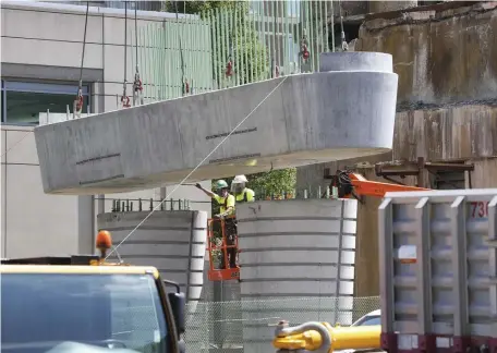  ?? NICOLAUS CZARNECKI / HERALD STAFF FIL ?? BIG JOB: Workers install a support for elevated tracks as part of the MBTA Green Line extension project in Cambridge in July. A $2 trillion federal infrastruc­ture bill could support transporta­tion projects such as this.