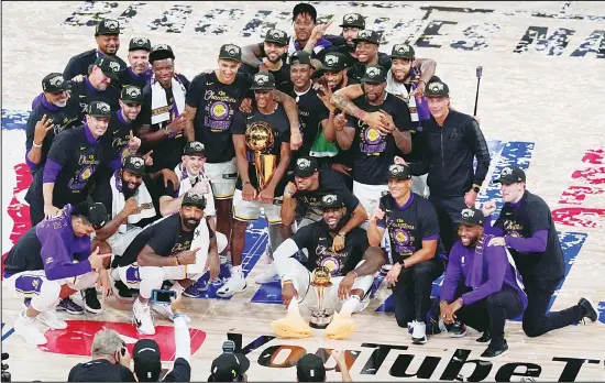  ??  ?? The Los Angeles Lakers players and coaches celebrate after the Lakers defeated the Miami Heat 103-88 in Game 6 of basketball’s NBA Finals on Oct 11, in Lake Buena Vista, Fla. (AP)