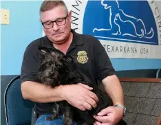 ?? Staff file photo ?? ■ In this 2018 file photo, Charles Lokey, then-director of Animal Care and Adoption Center in Texarkana, Ark., holds Velvet, a wire-haired terrier that has become the facility’s mascot. Velvet was a house surrender dog that was turned over by the owner and has become part of the family at Animal Care and Adoption Center.