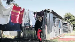  ?? / MDUDUZI NDZINGI ?? One of the residents who occupy Bakgomana Primary School hangs her laundry near her shack.
