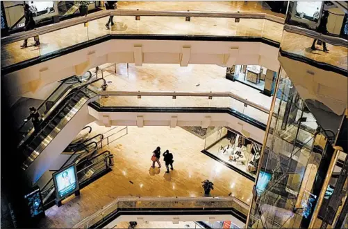  ?? ARMANDO L. SANCHEZ/CHICAGO TRIBUNE PHOTOS ?? Pedestrian­s walk through theWater Tower Place on Thursday in Chicago. Macy’s recently announced it’s closing its flagship store inWater Tower Place, leaving the department store space vacant for the first time since the eight-story mall opened in 1975 with Marshall Field’s as the anchor tenant.