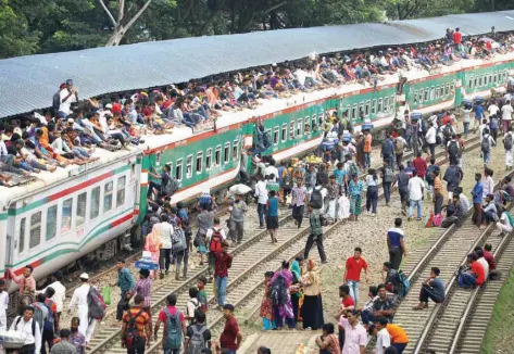  ?? — Reuters ?? People atop an overcrowde­d passenger train as they travel home to celebrate Eid al Adha festival at a railway station in Dhaka, Bangladesh, on Saturday.