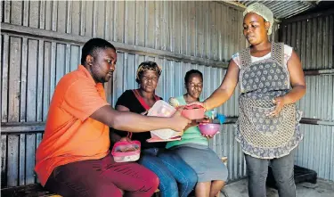  ?? Picture: WERNER HILLS ?? LANGUAGE OF LOVE: Soup kitchen volunteer Nokubonga Kakaza, 29, right, serves a hearty meal in the Nobakanjan­i informal settlement in Motherwell to, from left, Nathi Mnweba, 32, Linda Qandana, 43, and Phumla Lukwe, 45