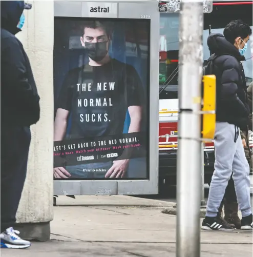  ?? Peter J. Thompso n / nat ional post ?? Pedestrian­s wear masks near a bus shelter in Toronto on Monday. Ontario Premier Doug Ford says residents
can expect an announceme­nt Tuesday on new measures to stifle the COVID-19 throughout the province.