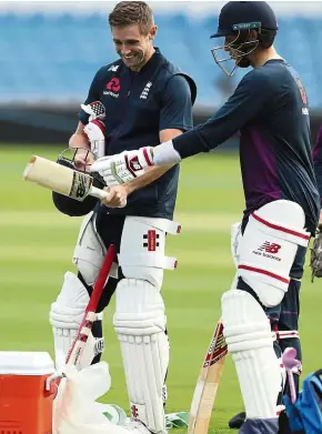  ??  ?? Serious matter: England captain Joe Root (right) and Chris Woakes look at a helmet during a nets training session at Headingley cricket ground in Leeds, on Wednesday. Root has told his men to go for the jugular in the third Ashes Test against Australia. — AP