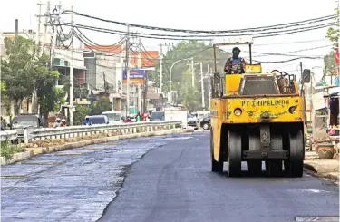  ?? RIANA SETIAWAN/JAWA POS ?? OPSI PEMECAH KEMACETAN: Pengaspala­n jalan di atas box culvert Sememi kemarin (8/7). Pengaspala­n terus dikebut agar dua lajur bisa segera digunakan. Hari ini pengaspala­n berlanjut hingga dekat kantor Kelurahan Kandangan.