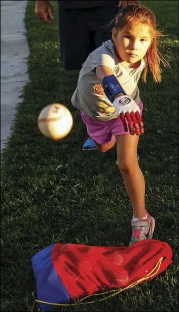  ?? Joel Angel Juarez Las Vegas Review-Journal ?? Hailey Dawson, 7, of Henderson practices her pitching Thursday at Anthem Hills Park in Henderson. A group of UNLV professors and students created a 3-D prosthetic hand for Dawson.