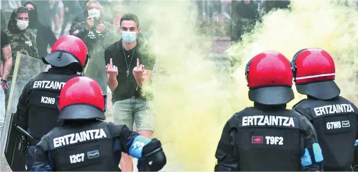  ?? EFE ?? La Ertzaintza, el pasado viernes en Sestao cuando radicales trataron de boicotear un mitin de Vox lanzando piedras, botellas y botes de humo