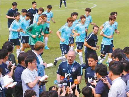  ?? Yonhap ?? Korean national football team players are seen during a training session while head coach Uli Stielike talks with reporters at Paju National Football Center in Gyeonggi Province, Monday.