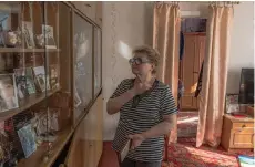  ?? ?? Valentyna Kozyr, 56, looks at the photos of her relatives who were killed by Russian missile attack on a cafe, at her house in the village of Groza, Kharkiv region.