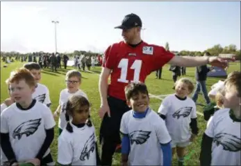  ?? MATT DUNHAM — THE ASSOCIATED PRESS ?? Eagles quarterbac­k Carson Wentz joins in with an NFL Flag event for local schoolchil­dren after practice at the London Irish rugby team training ground in the Sunbury-on-Thames on Friday.