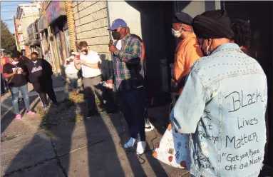  ?? Christian Abraham / Hearst Connecticu­t Media ?? Charles Nixon, father of Nyair Charles Nixon Jr., in center holding microphone, speaks during a protest in front of the now shuttered Keystone Mens Club on Barnum Avenue in Bridgeport on Thursday.