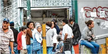  ?? Foto: Roman Camacho, dpa ?? Es gibt nichts zu kaufen und damit auch nichts zu essen: Menschen vor einem Laden in der venezolani­schen Hauptstadt Caracas, dessen Regale wieder einmal leer sind.