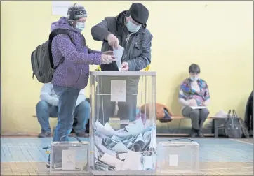  ?? DMITRI LOVETSKY — THE ASSOCIATED PRESS ?? People cast their ballots during the State Duma, the Lower House of the Russian Parliament and local parliament­s elections at a polling station in St. Petersburg, Russia on Friday.